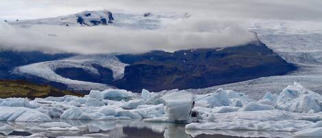 A glacier with icebergs and a mountain in the background.