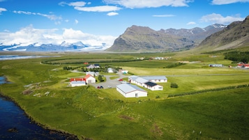Un paisaje rural con un pequeño asentamiento, casas y un río.