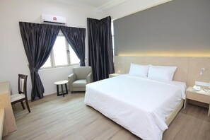 A hotel room with a large bed, a chair, a small table, and a nightstand with a phone. - Summit Signature Hotel Batu Pahat (Batu Pahat)
