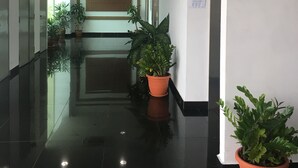 A clean, modern hallway with potted plants, a sign indicating a toilet, and a door with a handle. - Summit Signature Hotel Batu Pahat (Batu Pahat)