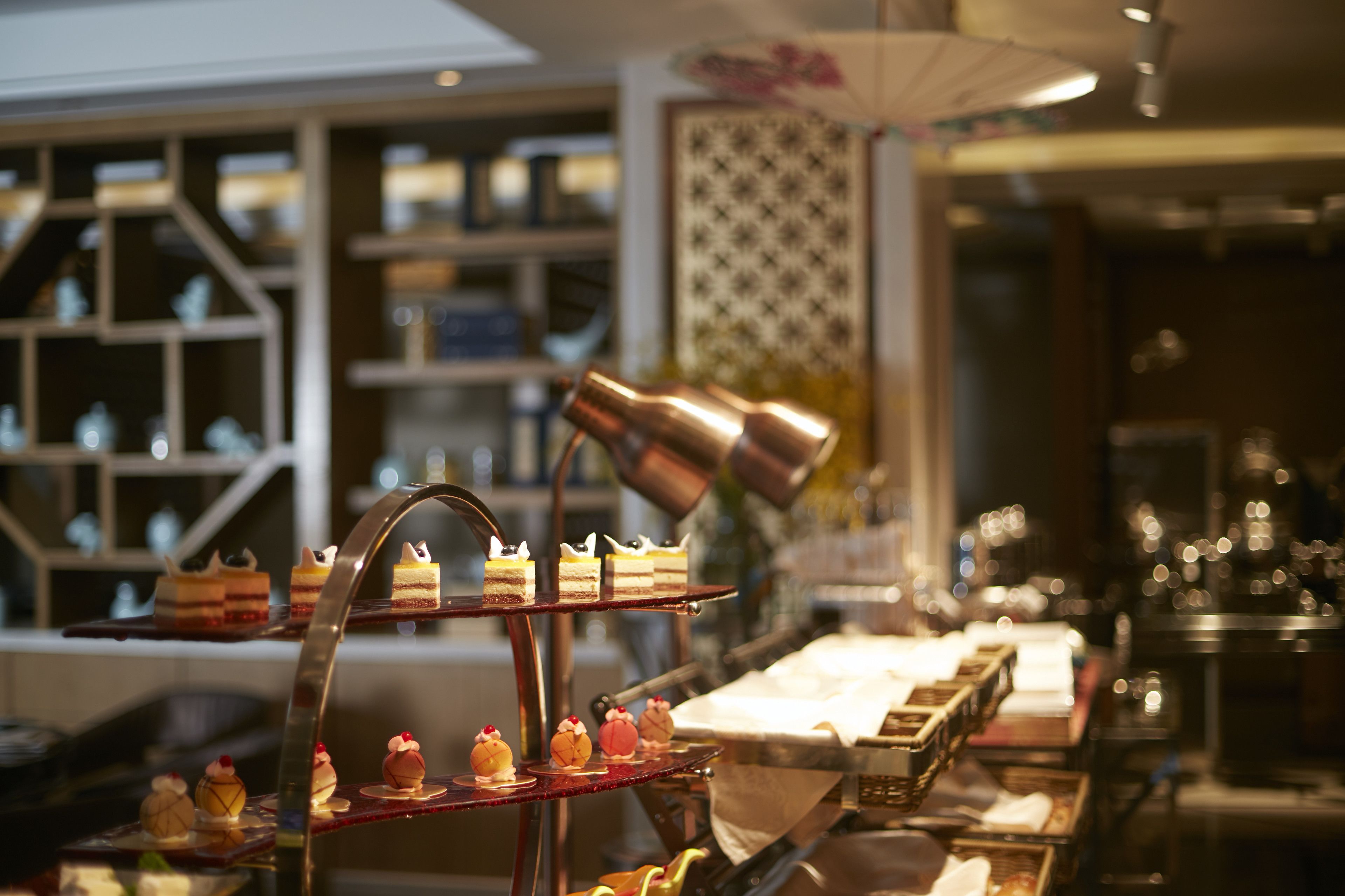 A dessert display with various cakes and pastries on a multi-tiered stand.