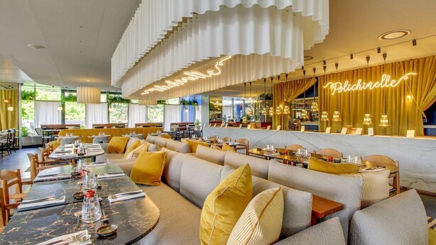 A modern restaurant with a bar area, seating arrangements, and a neon sign. - Yooma Urban Lodge Tour Eiffel (Paris)