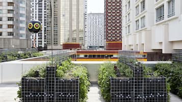 A rooftop garden with planters and a spherical sculpture.