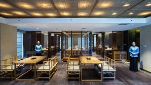 A restaurant with wooden furniture and a modern ceiling design. - Blossom  Tao Hotel （Hangzhou Olympic Center） (Hangzhou)