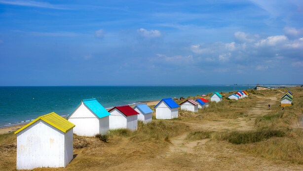 A row of beach huts with colorful roofs along a coastal path. - Village de vacances Le Sénéquet (Blainville-sur-Mer)