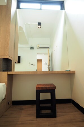 A small room with a wooden bench, a large mirror, and a door leading to another room. - T Hostel at Victory Monument (Bangkok)