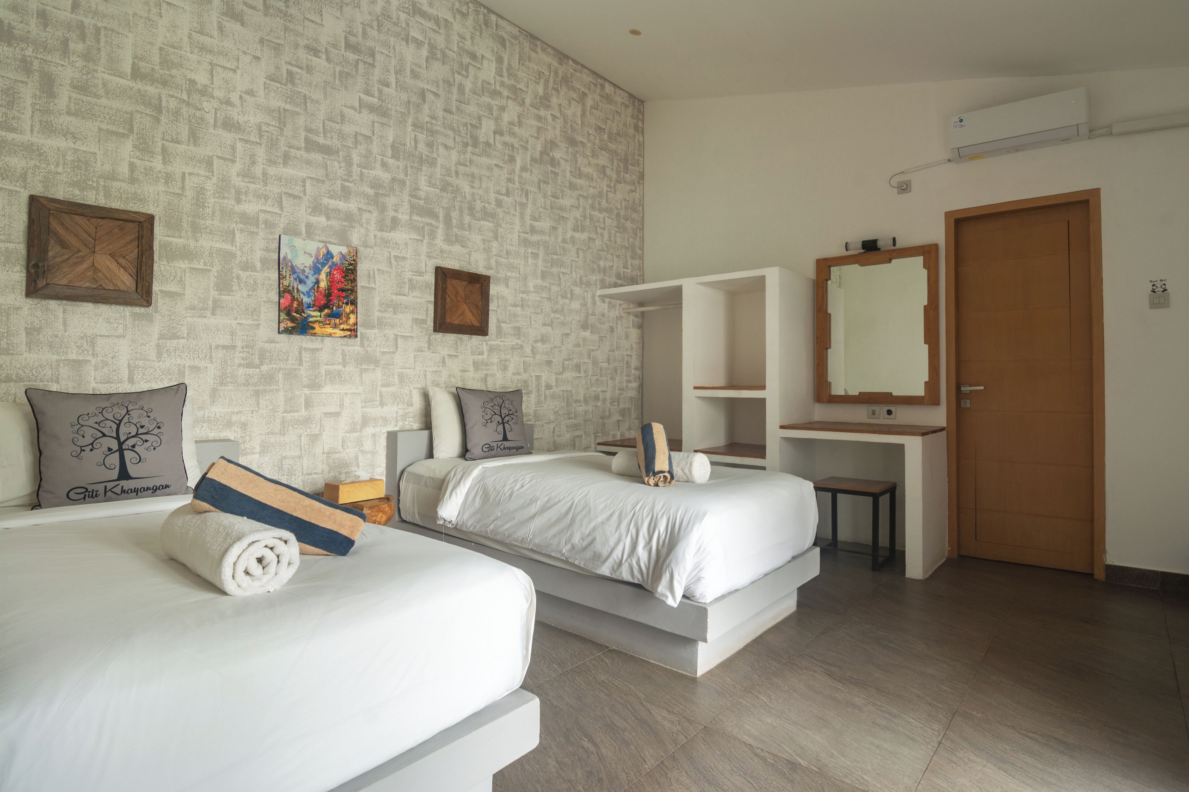 Ein modernes Hotelzimmer mit zwei Betten, einem großen Spiegel, einem Kleiderschrank und einem kleinen Schreibtisch.