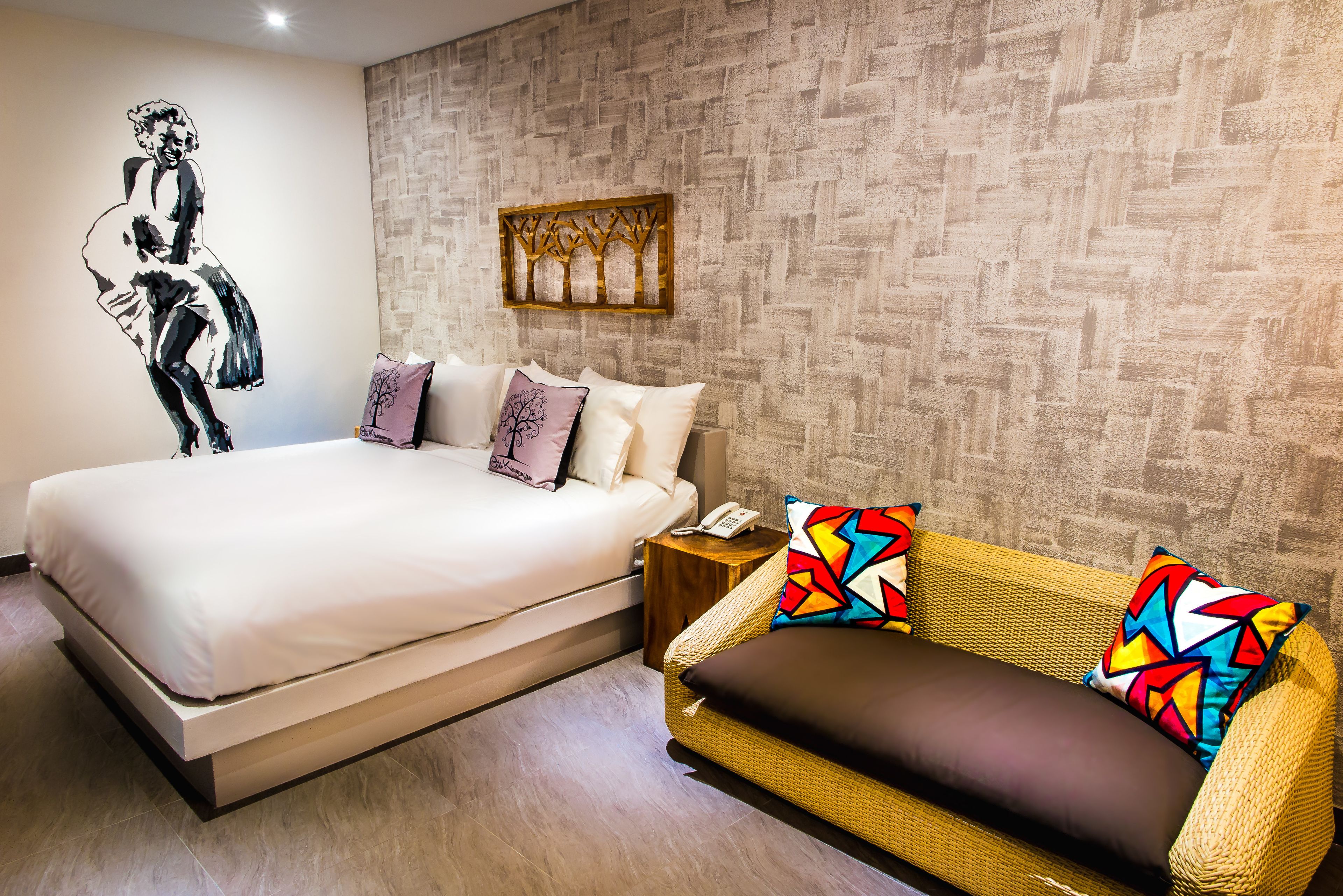Un dormitorio con cama, sofá, teléfono de pared y un adorno en la pared.