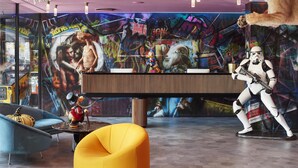 Een modern interieur met een muurschildering, een leeuwenbeeld, een Stormtrooper figuur en eigentijds meubilair.