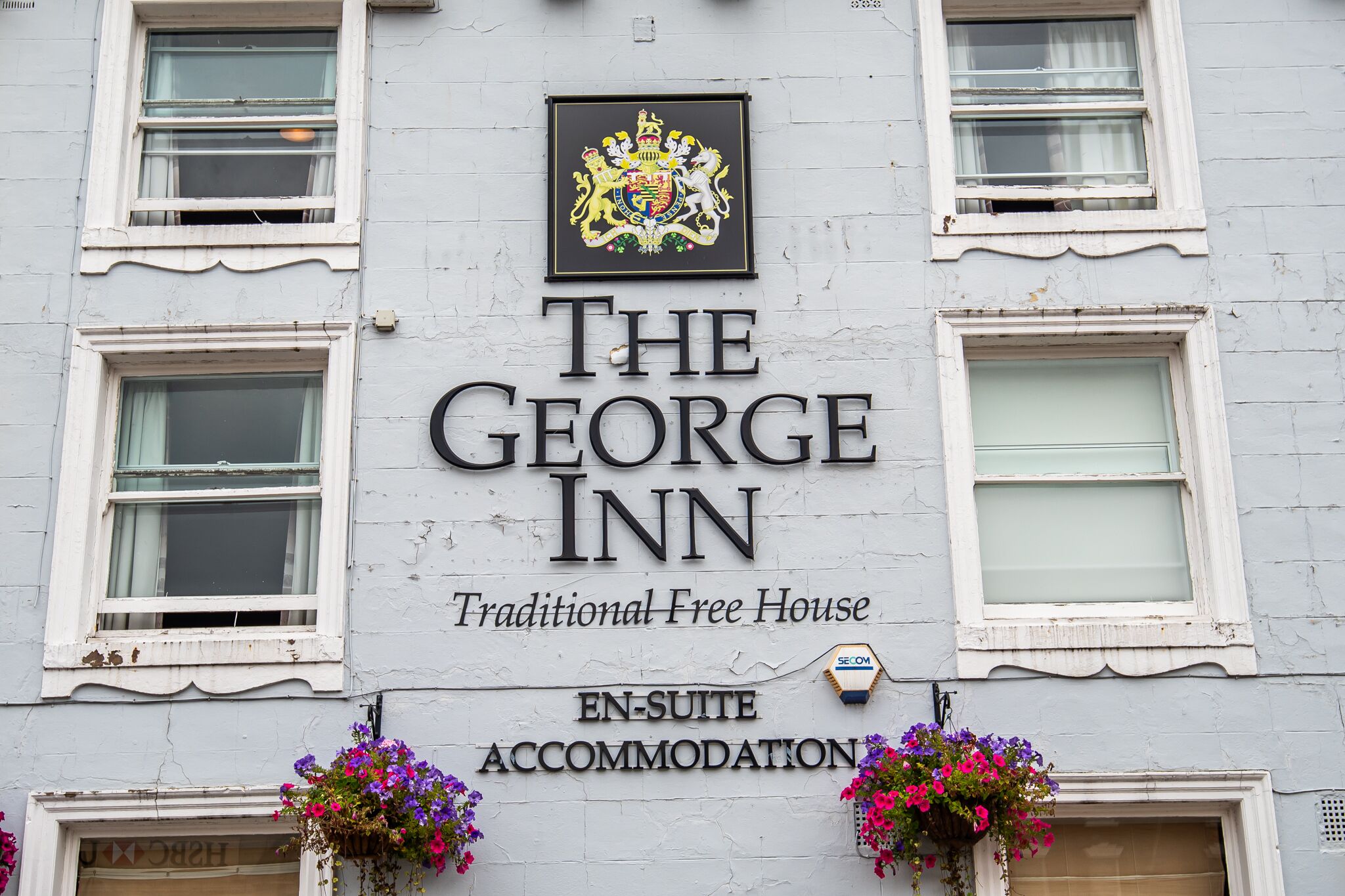 Un bâtiment portant une enseigne indiquant « The George Inn » et « Traditional Free House », ce qui signifie qu’il s’agit d’un établissement historique.