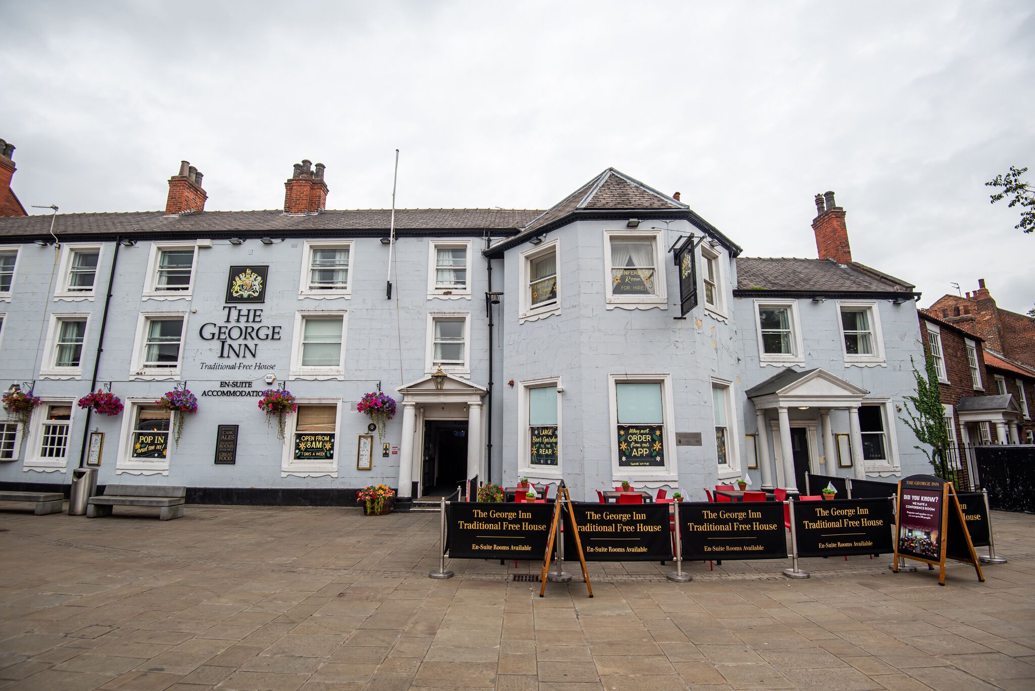 A traditional building with multiple windows and a sign reading 'The George Inn.'