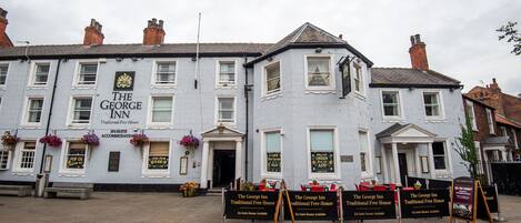 A traditional building with multiple windows and a sign reading 'The George Inn.'