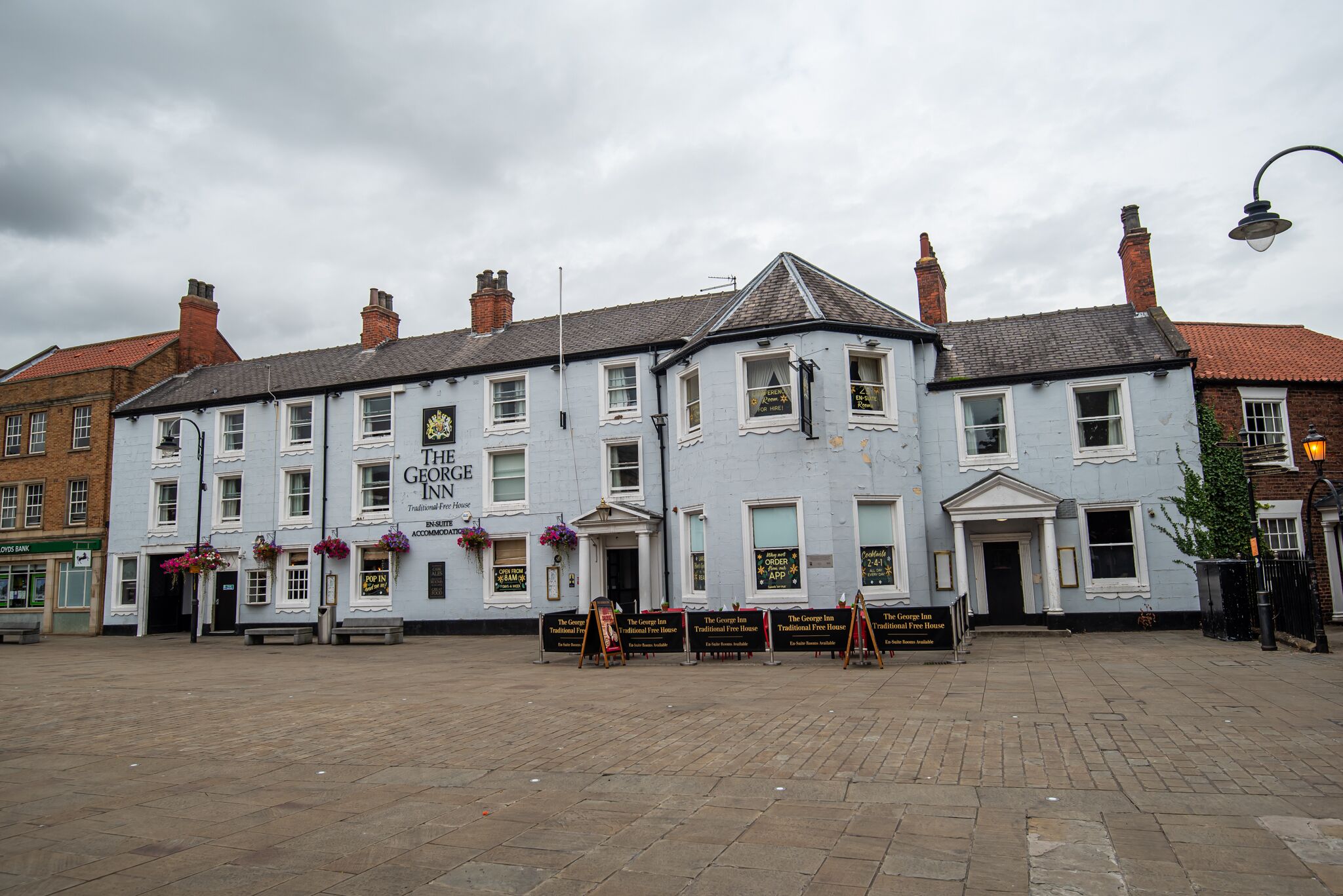 A traditional inn with a white facade, multiple windows, and a prominent entrance.