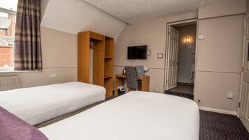 Habitación de hotel con dos camas, un armario, televisión y una puerta que da a un baño.