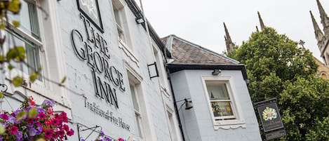 Un edificio con el letrero 'The George Inn', que indica una taberna tradicional independiente.