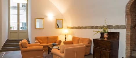 Una sala de estar con un sofá, una mesa de centro, una lámpara y una chimenea.