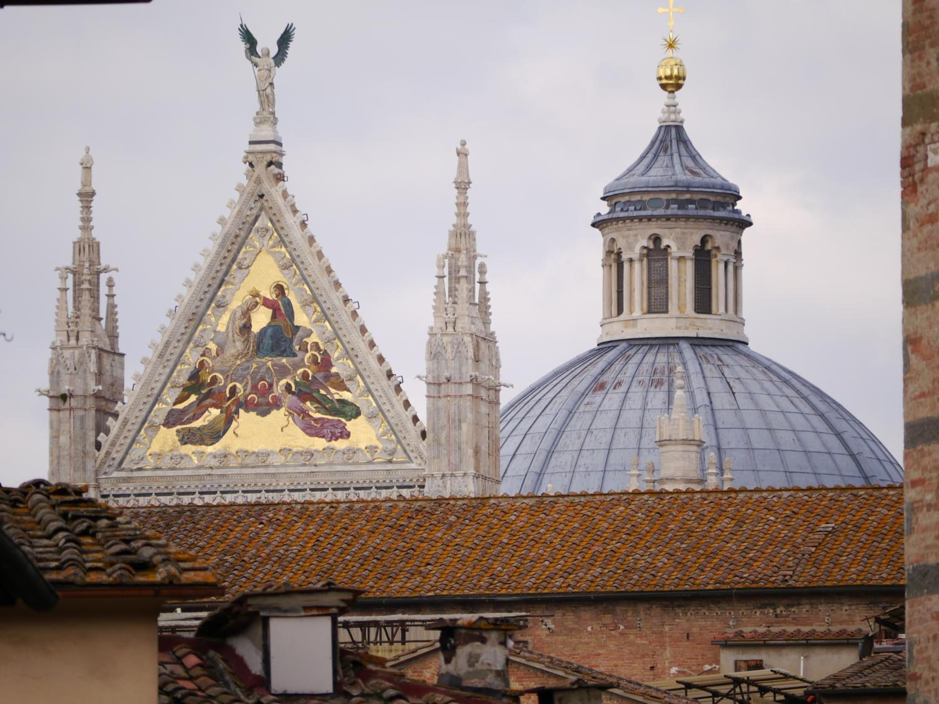 A historic building with a large dome and a triangular roof with a golden mosaic.