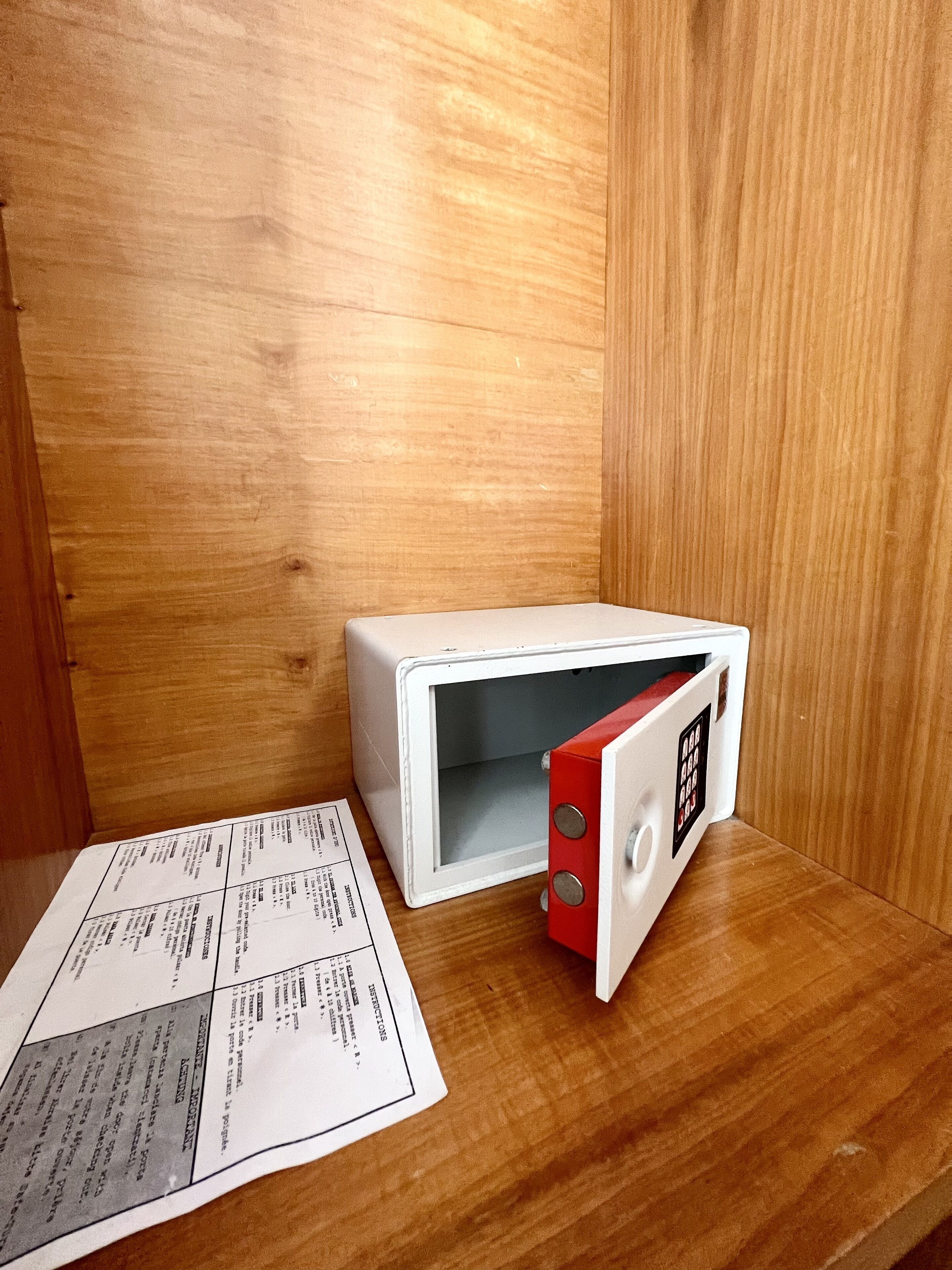 A microwave oven placed on a wooden surface with a manual beside it.