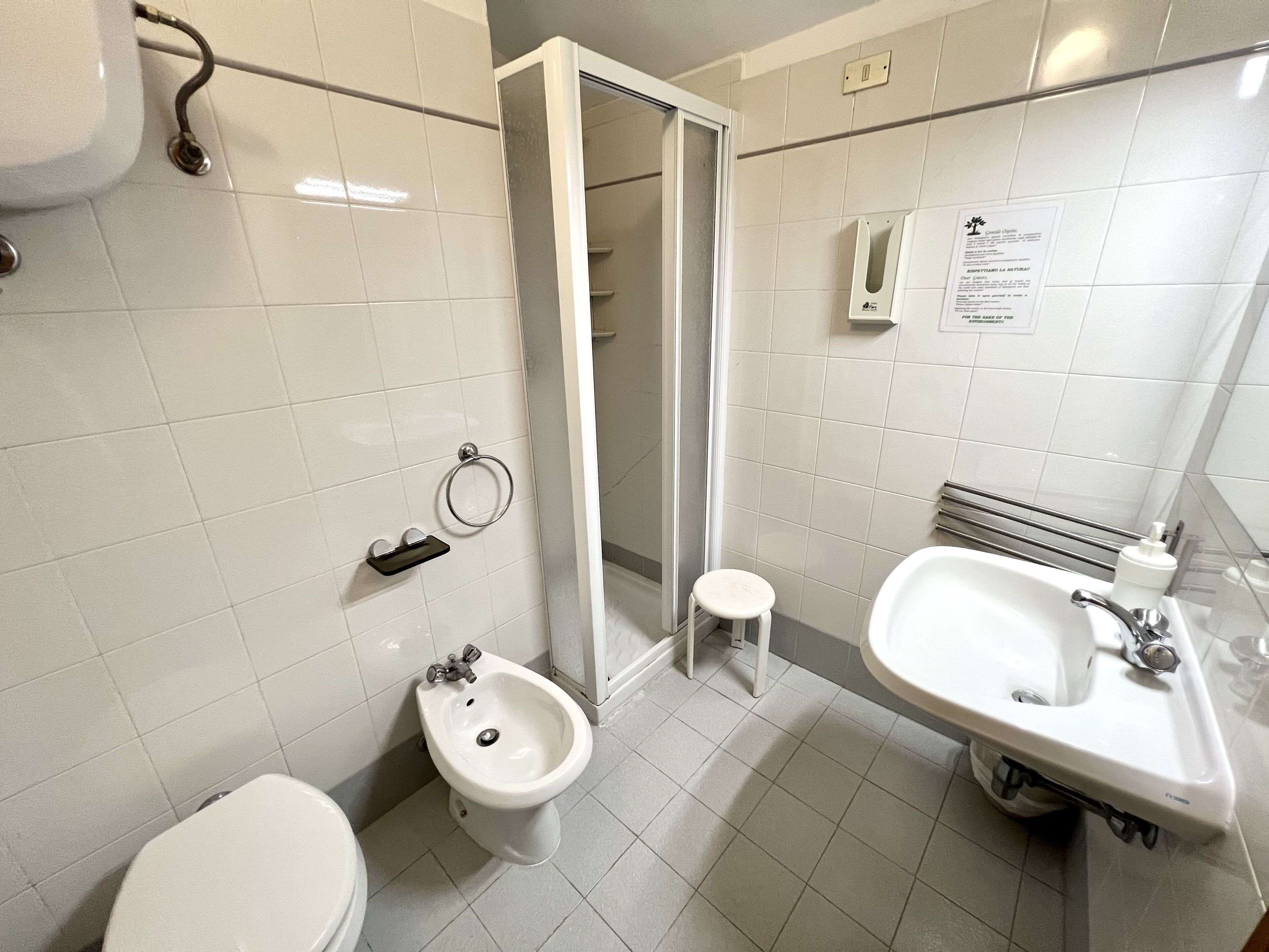 A modern bathroom with a toilet, bidet, and two sinks.