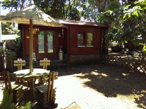 A wooden cabin with a thatched roof, a wooden table, and chairs. - Vilar dos Carvalhinhos (Praia da Vitoria)
