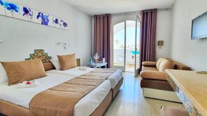 A hotel room with two beds, a sofa, a TV, and a view of the outdoors. - Zenon Hotel Djerba (Mezraia)