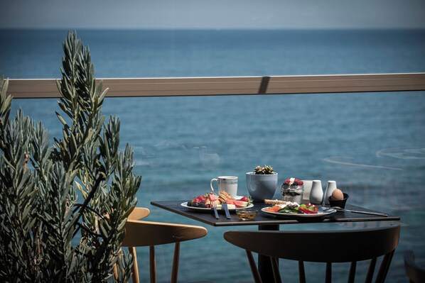 A table with food and drinks on a balcony overlooking the sea. - Serenity Spritz Hotel - Adults Only (Hersonissos)