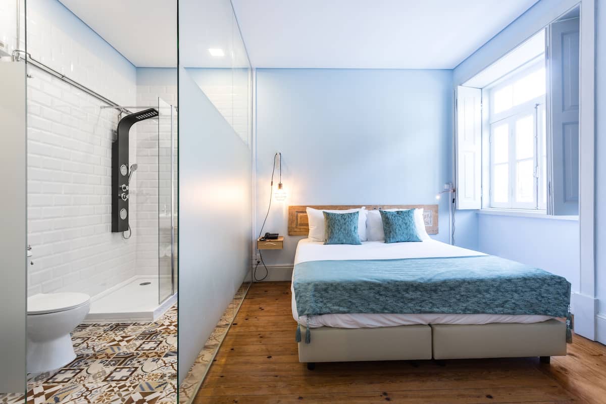 Un dormitorio moderno con una cama grande, una mesita de noche y un ventanal.