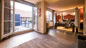 Quarto com cama de dossel, uma grande porta de correr e vista para uma área residencial.