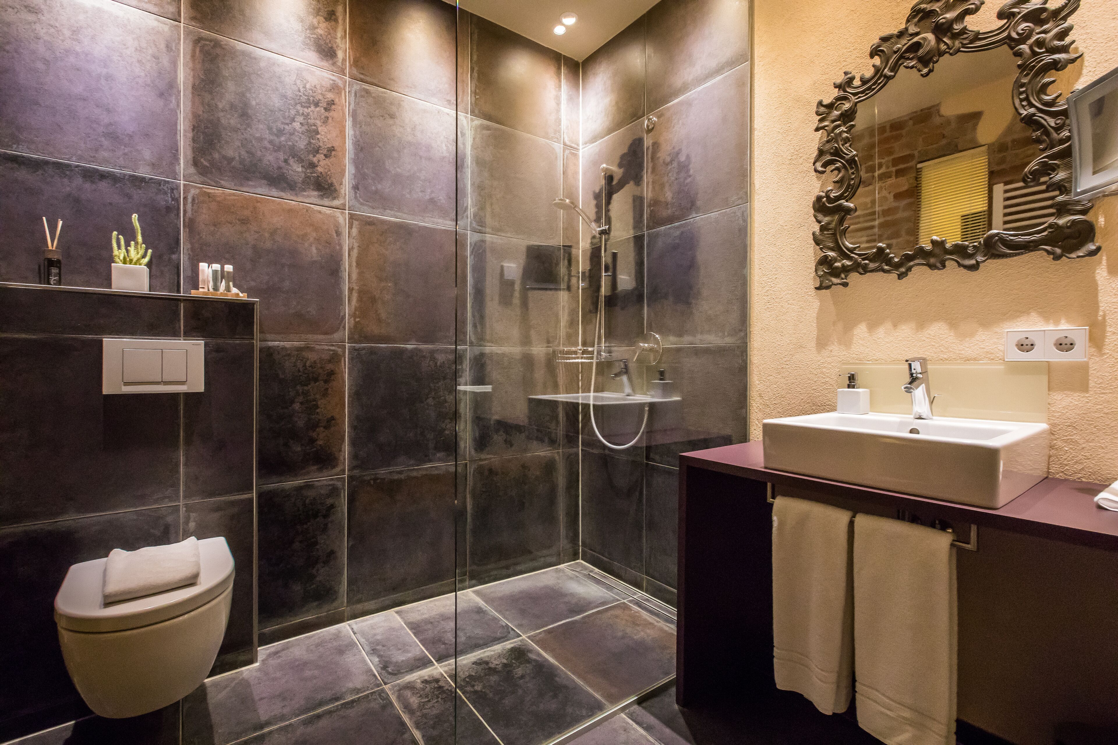 Een moderne badkamer met een glazen douchecabine, een toilet en een wastafel met spiegel.