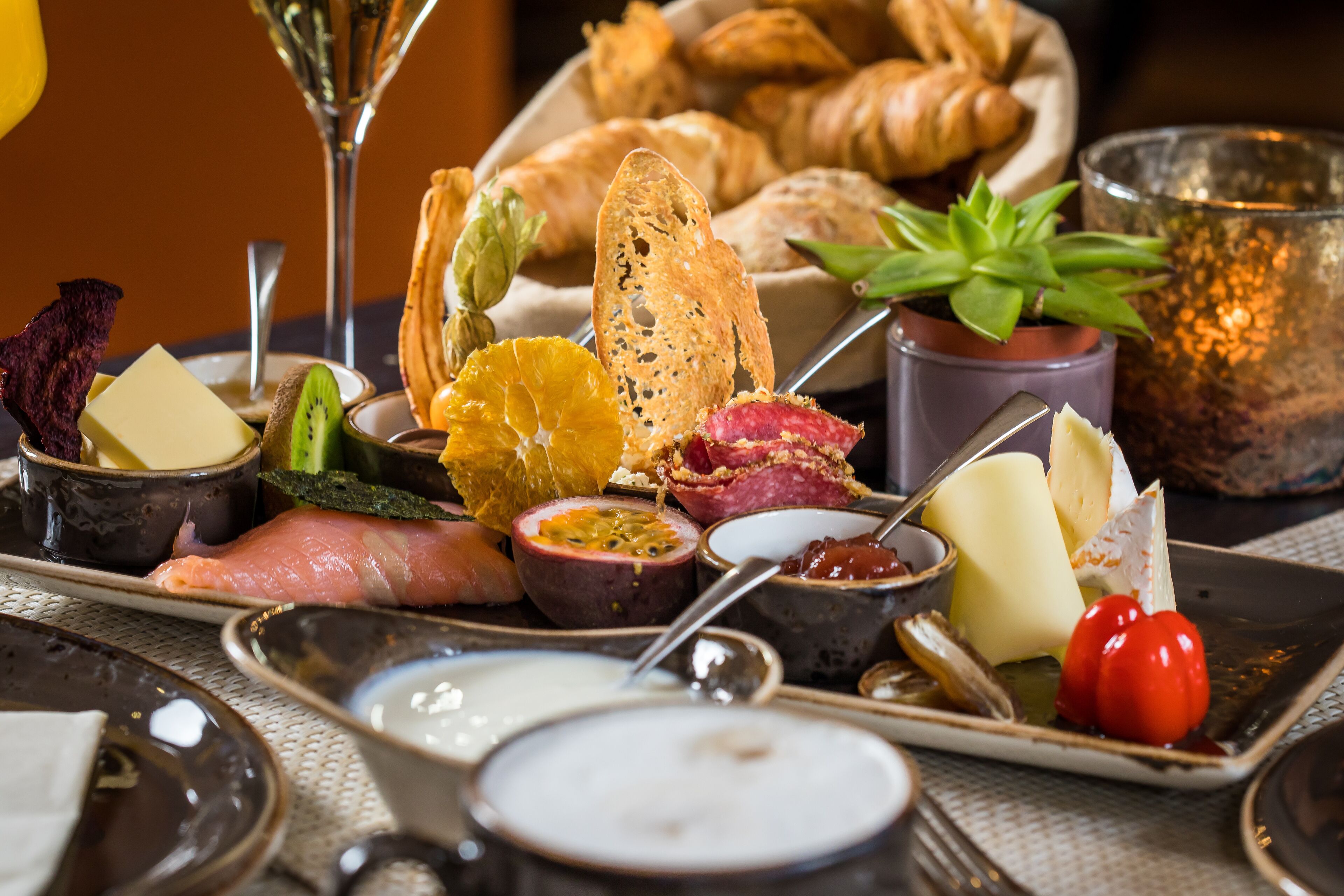 Eine Platte mit verschiedenen Käsesorten, Wurstwaren, Früchten und Brot.