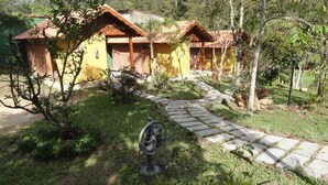 Un edificio rústico con un camino empedrado que lo lleva a él, rodeado de follaje.