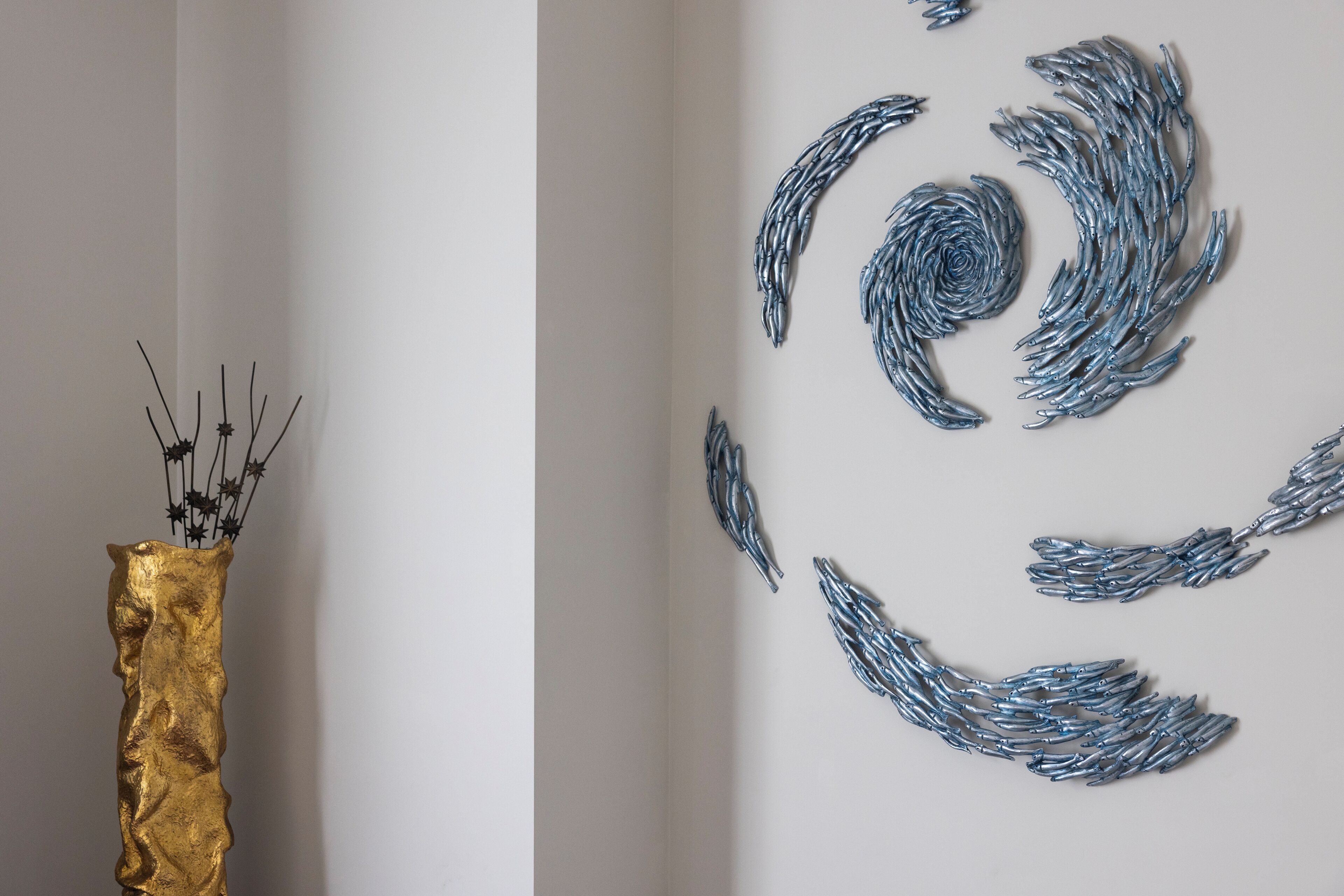 Ein Zimmer mit einer Goldvase und einem Wandbild.