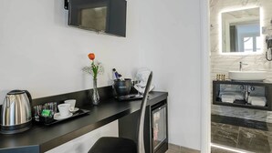 Un bagno moderno con uno specchio grande, un lavandino e una televisione a parete.