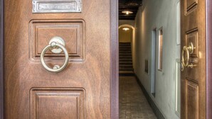 Una porta in legno con un bussolotto di ottone e una targa che riporta la scritta 'LETTERE'.