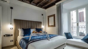 Una camera da letto con un letto, comodini, una panca finestra e vista esterna.