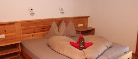 A wooden bed with a mattress, pillows, and a tag on the pillow.