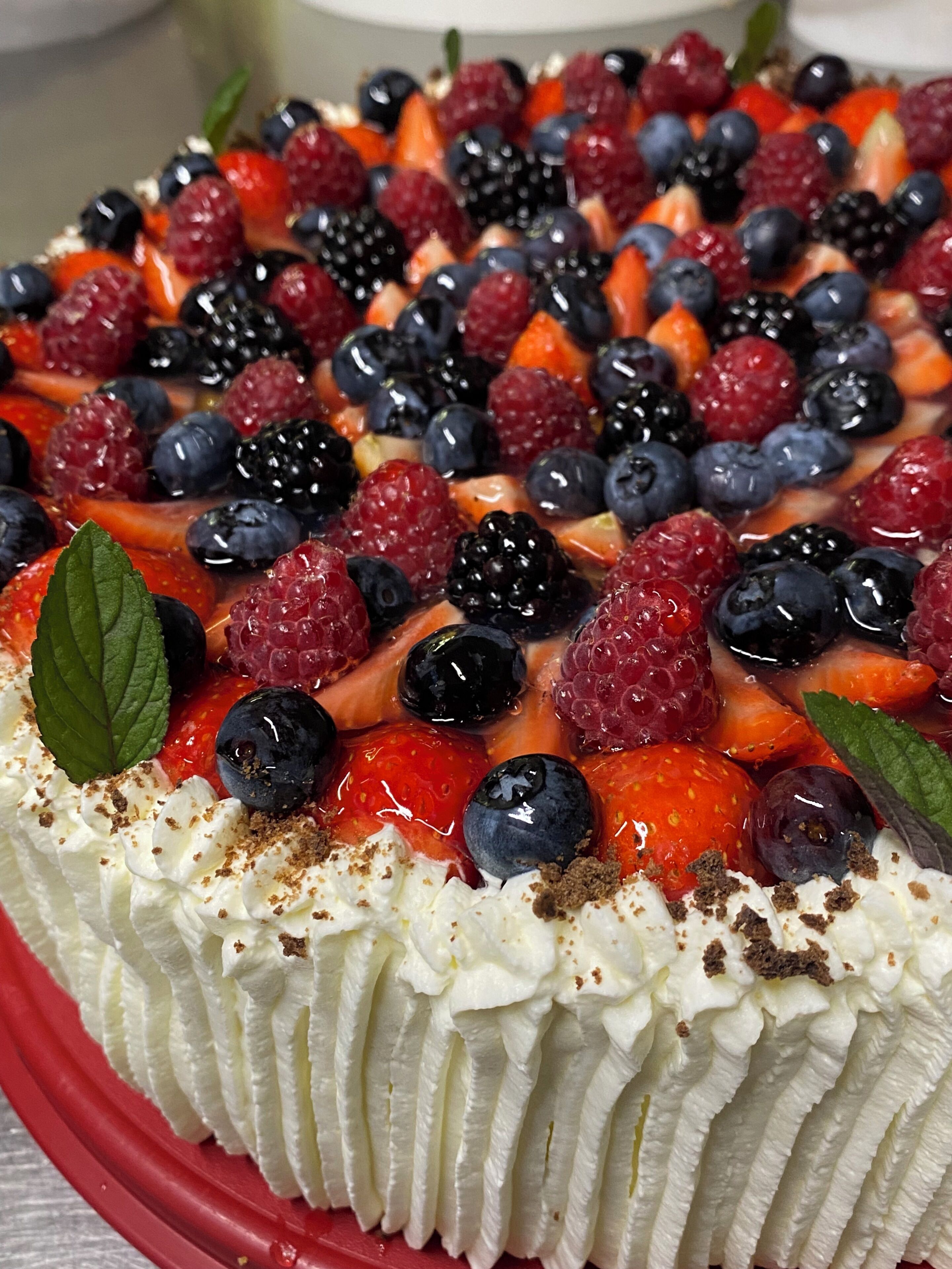 A dessert with whipped cream, strawberries, blueberries, and blackberries.