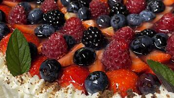 Ein Dessert mit Schlagsahne, Erdbeeren, Blaubeeren und Brombeeren.