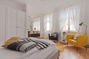 A modern bedroom with a bed, a desk, a chair, and a sofa. - Imperial Apartments - Classic (Sopot)
