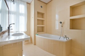 Un baño moderno con bañera, lavamanos y ducha.