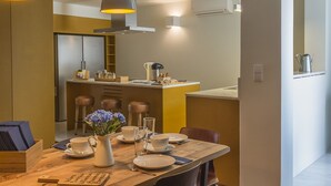Una cucina moderna con isola centrale, tavolo da pranzo in legno e sedie nere.