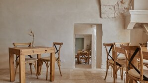 Un comedor rústico con mobiliario de madera y suelo de piedra.