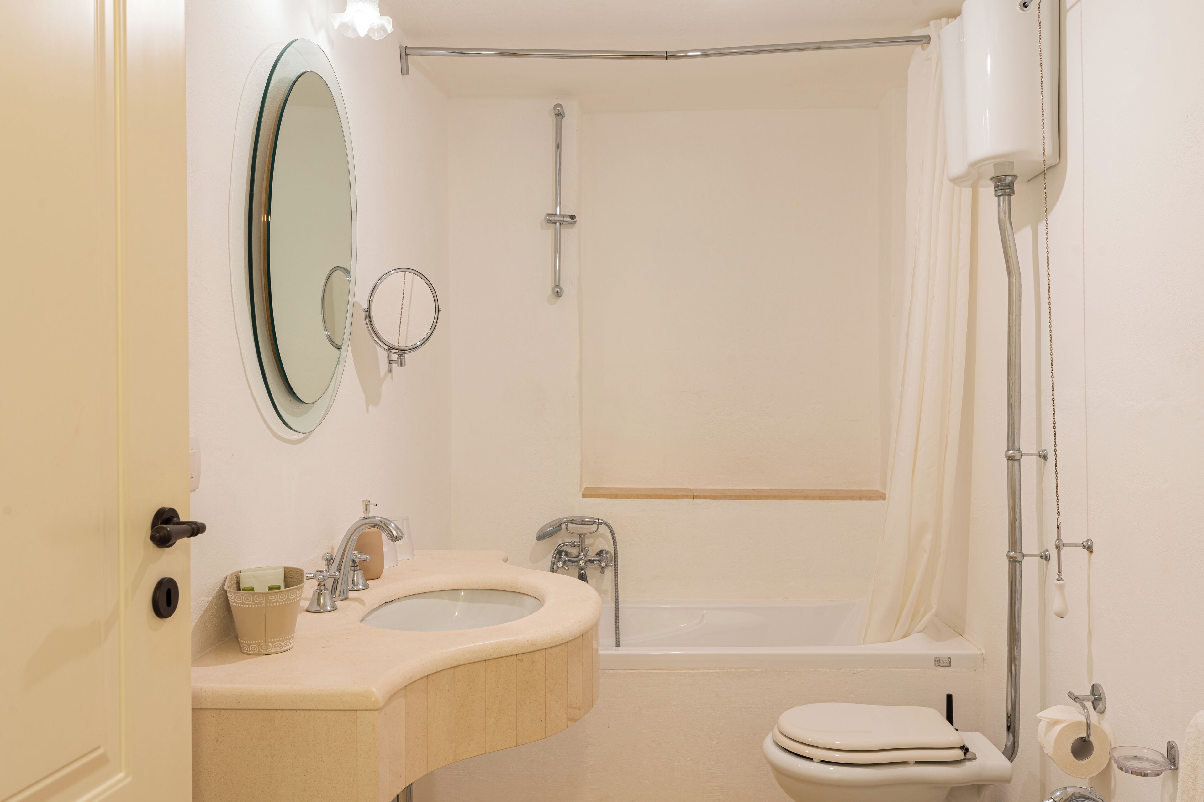 Ein Badezimmer mit Waschbecken, Spiegel, Toilette und Badewanne.