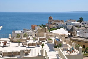A rooftop terrace with outdoor seating and a view of the sea. - Est Hotel (Santa Cesarea Terme)