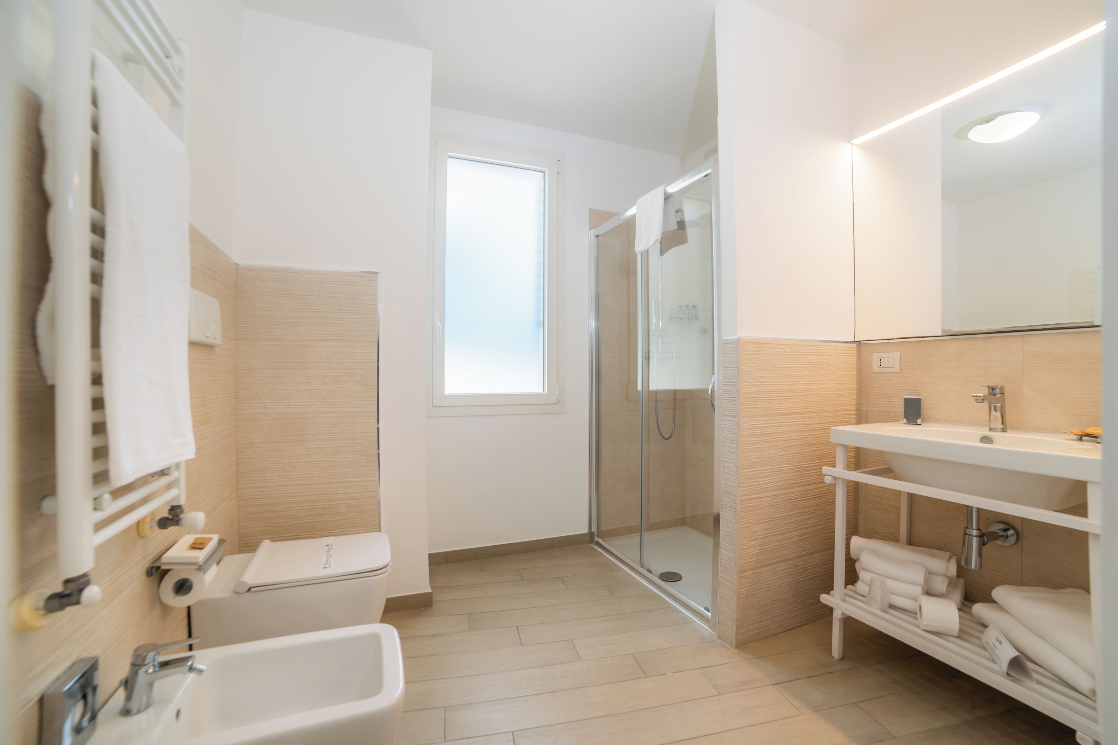 A modern bathroom with a shower, toilet, and sink.