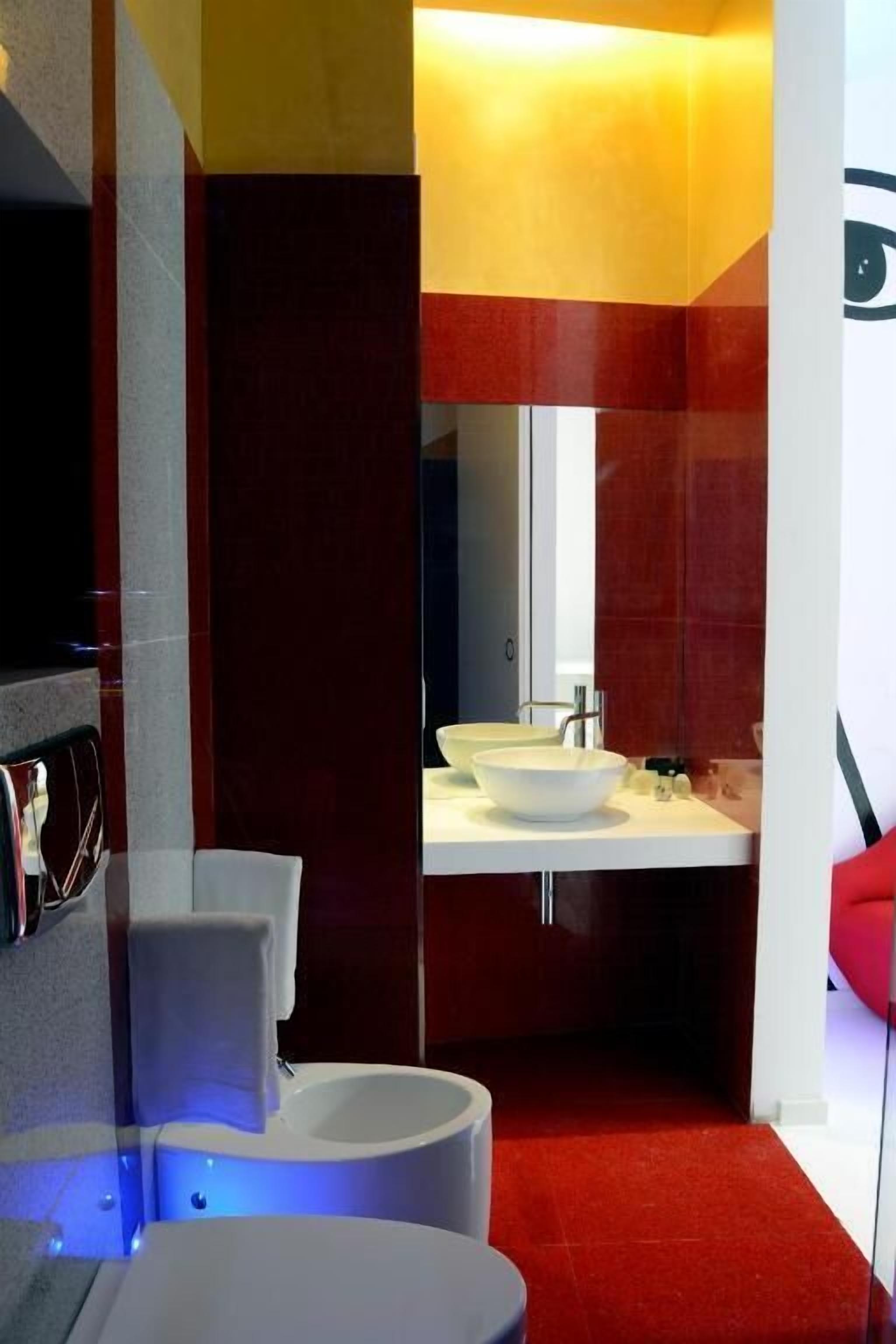A modern bathroom with a white sink, a toilet, and a bidet.