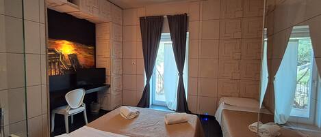 Une chambre d’hôtel équipée d’un lit, d’un bureau, d’une chaise et d’un téléviseur.
