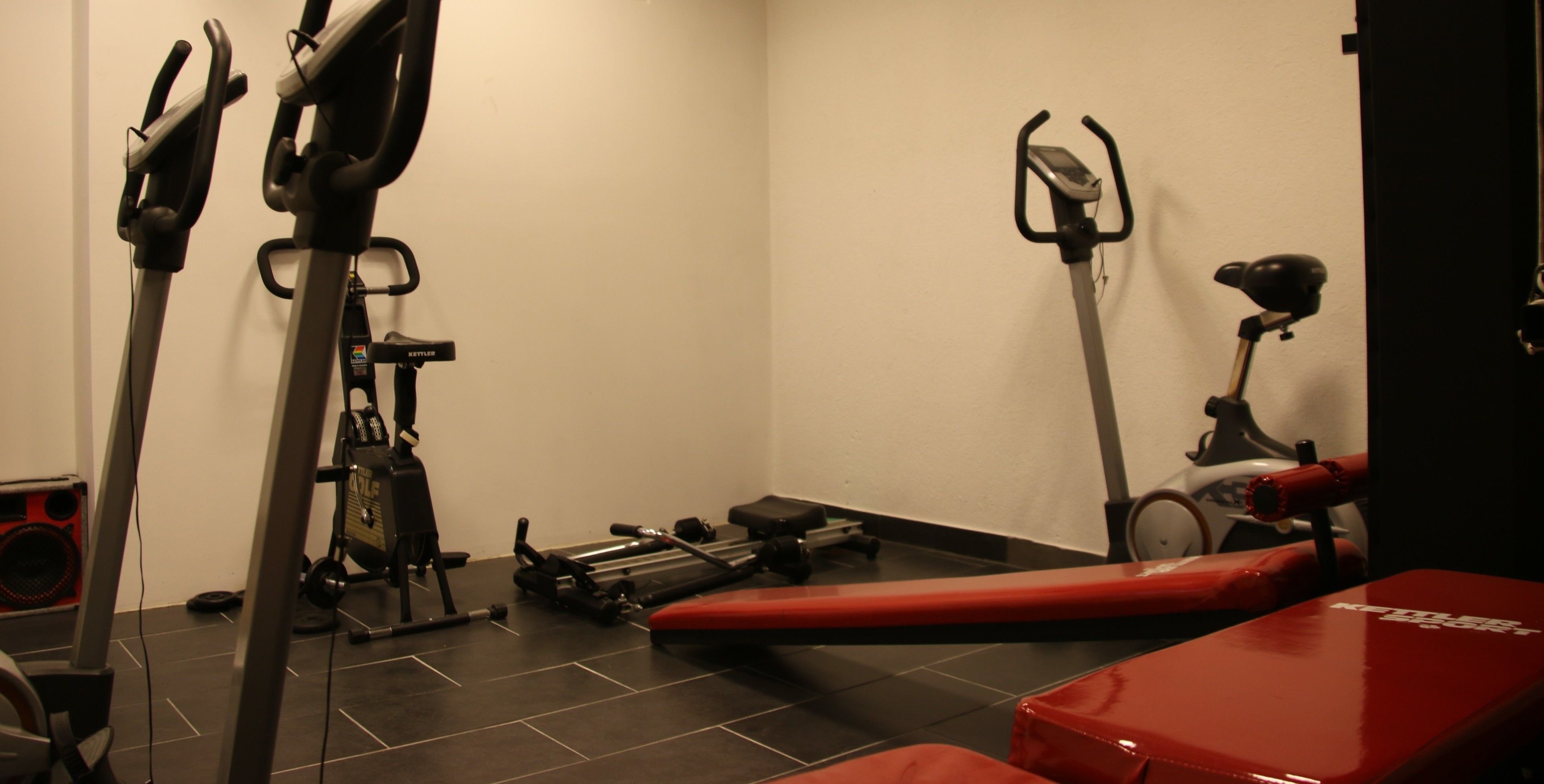 A gym with exercise equipment including a treadmill, stationary bike, and weights.