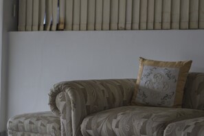 A sofa with a patterned fabric and a decorative pillow.