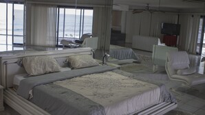 Ein geräumiges Schlafzimmer mit einem großen Bett, einer Couch und einem Fernseher.